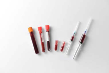 Kan ve beyaz arka plan üzerinde şırınga ile test tüpleri. Sağlık kavramı