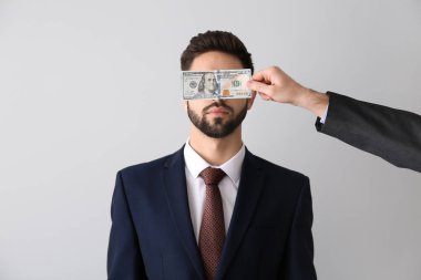 İşadamı karşı açık renkli gözleri kapsayan rüşvet adam. Yolsuzluk kavramı