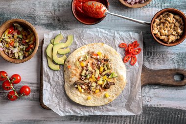 Ahşap masa üzerinde doldurma ile lezzetli tortilla