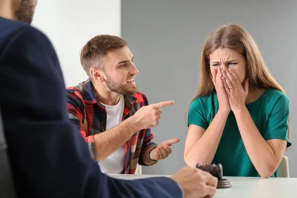 Young emotional couple visiting divorce lawyer in office