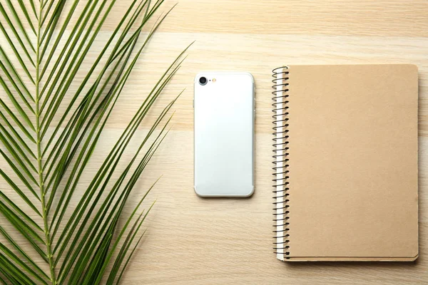 Notebook Telefon Komórkowy Liść Palmowy Drewnianym Stole — Zdjęcie stockowe