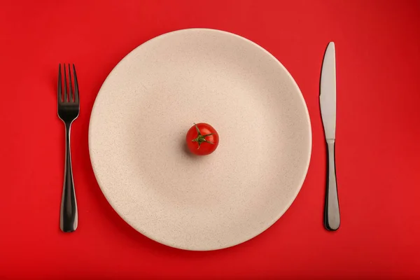 Assiette Avec Une Tomate Des Couverts Sur Fond Couleur Concept — Photo