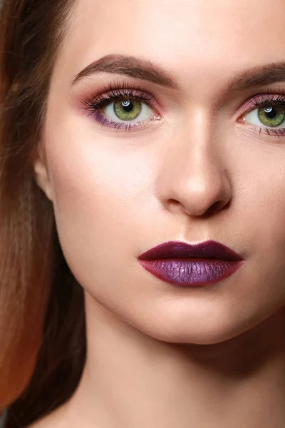 Young woman with makeup in violet tones, closeup