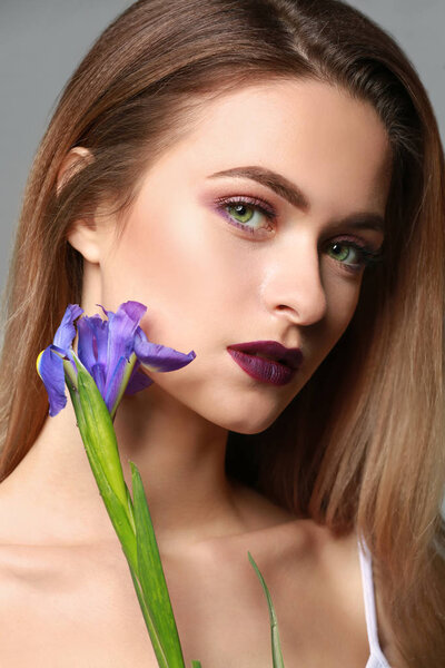 Красивая девушка с цветами на сером фоне