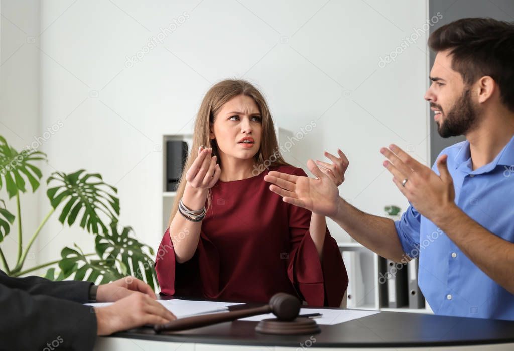 Young emotional couple visiting divorce lawyer in office