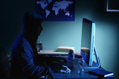 Profesyonel hacker karanlık odada bilgisayarla