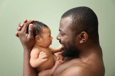 Mutlu Afrikalı-Amerikalı babası ile renk arka plan üzerinde küçük bebek portresi