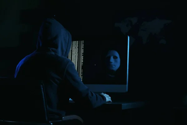 Professional hacker using computer in dark room