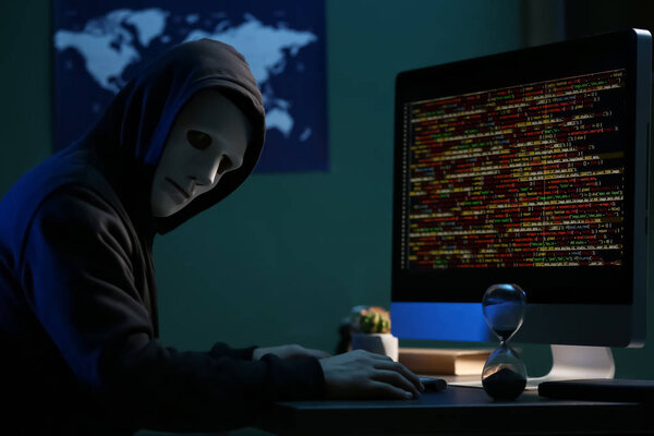 Professional hacker using computer in dark room