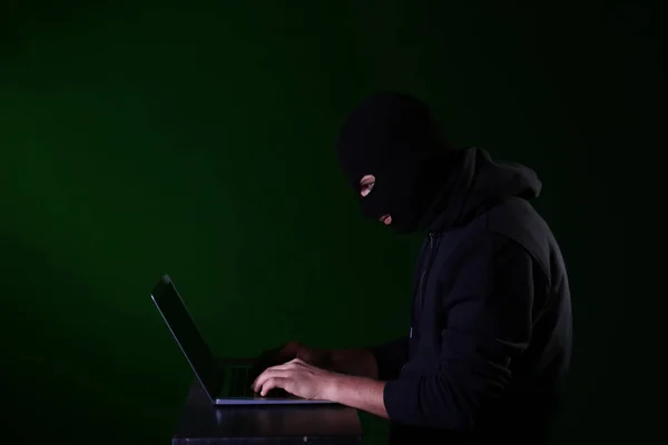 带有黑色背景笔记本电脑的专业黑客 — 图库照片