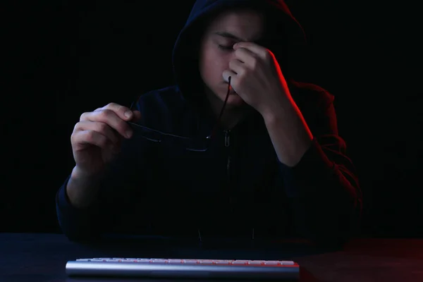 Hacker Cansado Com Teclado Computador Sentado Mesa Fundo Escuro — Fotografia de Stock