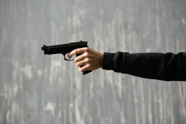 Gri arka plan üzerinde silahla erkek suçlu