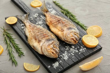 Izgara dorado balık ve gri arka plan üzerine limon ile Yönetim Kurulu