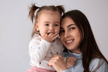 Işık arka plan üzerinde şirin küçük kızıyla birlikte Genç Anne