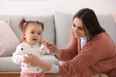 Genç kadın sevimli küçük kızıyla birlikte evde oynarken