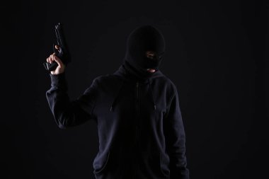Koyu arka plan üzerinde silahlı haydut