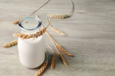 Ahşap masa üzerinde taze süt şişesi