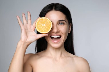 Doğal makyaj ve turuncu gri arka plan üzerinde olan güzel kadın portresi