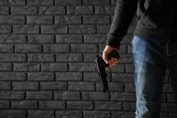 暗いレンガの背景に銃を持つ男性刑事 — ストック写真