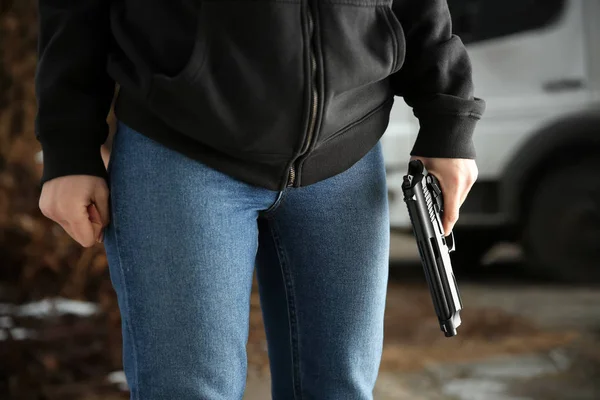 Woman with gun outdoors