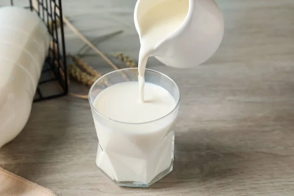 Gießen Von Frischer Milch Aus Krug Glas Auf Holztisch — Stockfoto