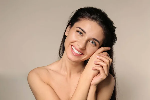 Portrait of beautiful young woman with natural makeup on light background