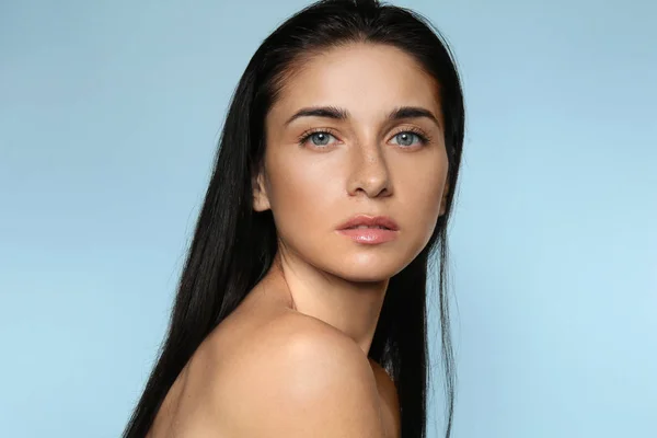 Portrait of beautiful young woman with natural makeup on color background