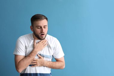 Genç adam renk arka plan üzerinde saldırı astım