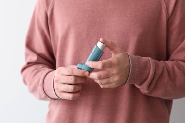Beyaz arka planda, closeup inhaler ile genç adam