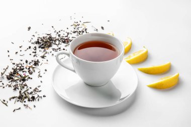 Beyaz arka planda bir fincan sıcak çay ve limon