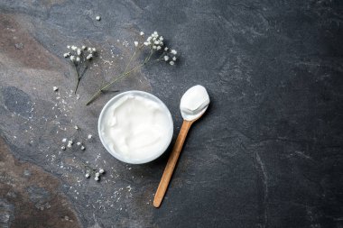 Kase ve lezzetli yoğurt koyu arka plan üzerine kaşıkla