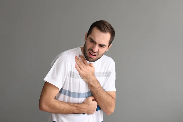 喘息の攻撃は灰色の背景を持つ若い男 — ストック写真