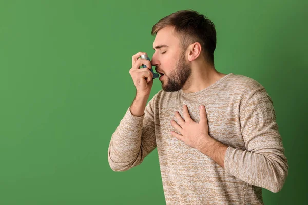 Junger Mann Mit Inhalator Hat Asthmaanfall Vor Farbigem Hintergrund — Stockfoto