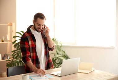 Ofiste çalışırken cep telefonu üzerinde konuşurken genç serbest meslek