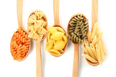 Beyaz arka plan üzerinde pişmemiş makarna ürün yelpazesine kaşıklarla