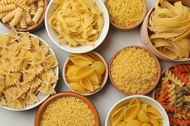 Pişmemiş makarna gri arka plan üzerinde ürün yelpazesine kase