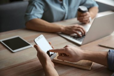 Kafede çalışan cep telefonu olan genç bir adam.