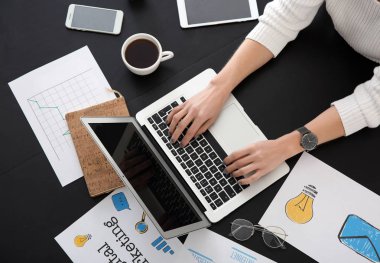 Ofiste masada dizüstü bilgisayarda çalışan genç kadın