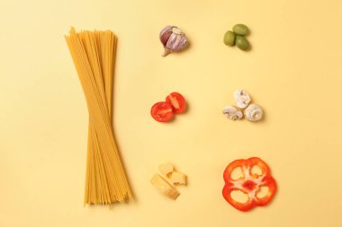 Renk arka plan üzerinde ürünlerle pişmemiş makarna