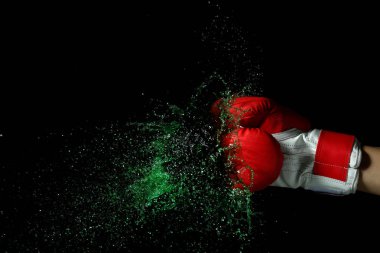 Boks eldiven koyu arka plan üzerinde sıvı sıçraması ile el