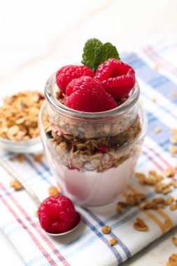 Ahududu ve masada yulaf ezmesi ile lezzetli yoğurt cam kavanoz