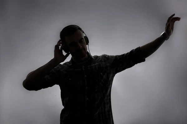 Silhouette Eines Jungen Mannes Der Musik Auf Grauem Hintergrund Hört — Stockfoto