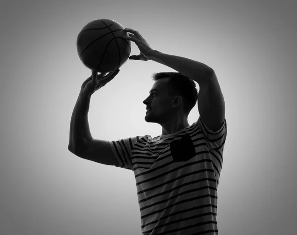 在灰色背景下打篮球的年轻人剪影 — 图库照片