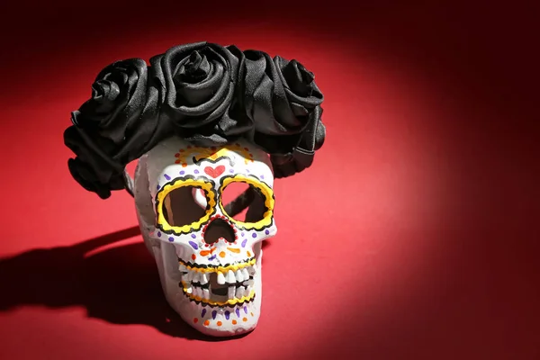 色の背景にメキシコの死者の日のための花輪で描かれた人間の頭蓋骨 — ストック写真