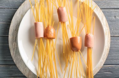 Plaka pişmemiş makarna ve sosis ahşap tablo