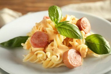 Delicious pasta with sausage on plate, closeup