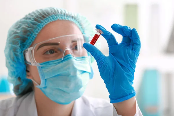 与血液样品在实验室工作的女人 — 图库照片