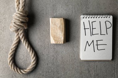 Rope with loop, soap and notebook with text HELP ME on grey background. Suicide concept