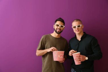 Renk arka plan film izlerken patlamış mısır ile genç erkek