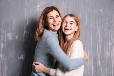 Mutlu anne ve kızı gri arka plan üzerinde portresi